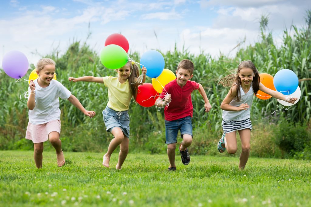 Kinder laufen auf der Wiese