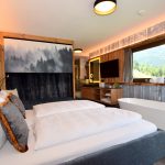 doppelbettzimmer_mit_freistehender_badewanne_und_traumhaftem_ausblick_chalets_apartments_wachterhof