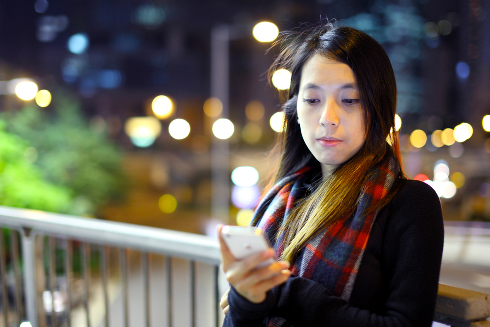 Asian,Woman,Using,Mobile,At,Night