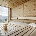 Das Sanarium¨ von KLAFS im Altholzstil im neuen Leni Mountain Chalet kombiniert ein klassisches Saunabad, ein Soft-Dampfbad, ein Aromabad und ein Warmluftbad. Die raumhohen Fenster holen die traumhaften Berge in den Raum.