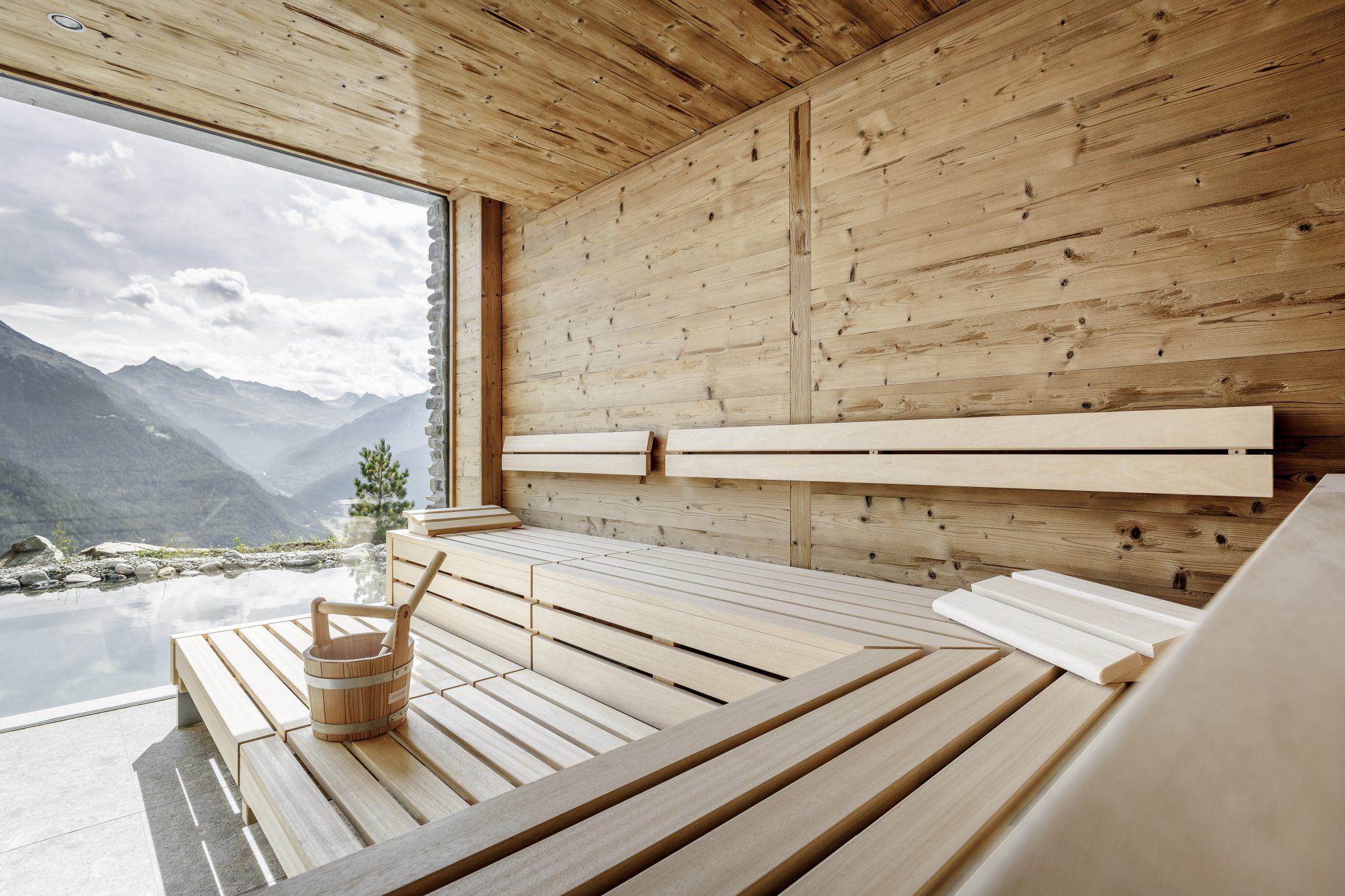 Das Sanarium¨ von KLAFS im Altholzstil im neuen Leni Mountain Chalet kombiniert ein klassisches Saunabad, ein Soft-Dampfbad, ein Aromabad und ein Warmluftbad. Die raumhohen Fenster holen die traumhaften Berge in den Raum.