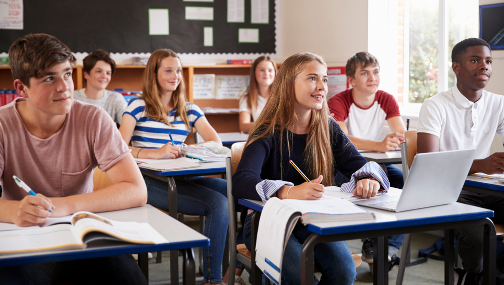 Students,Listening,To,Female,Teacher,In,Classroom