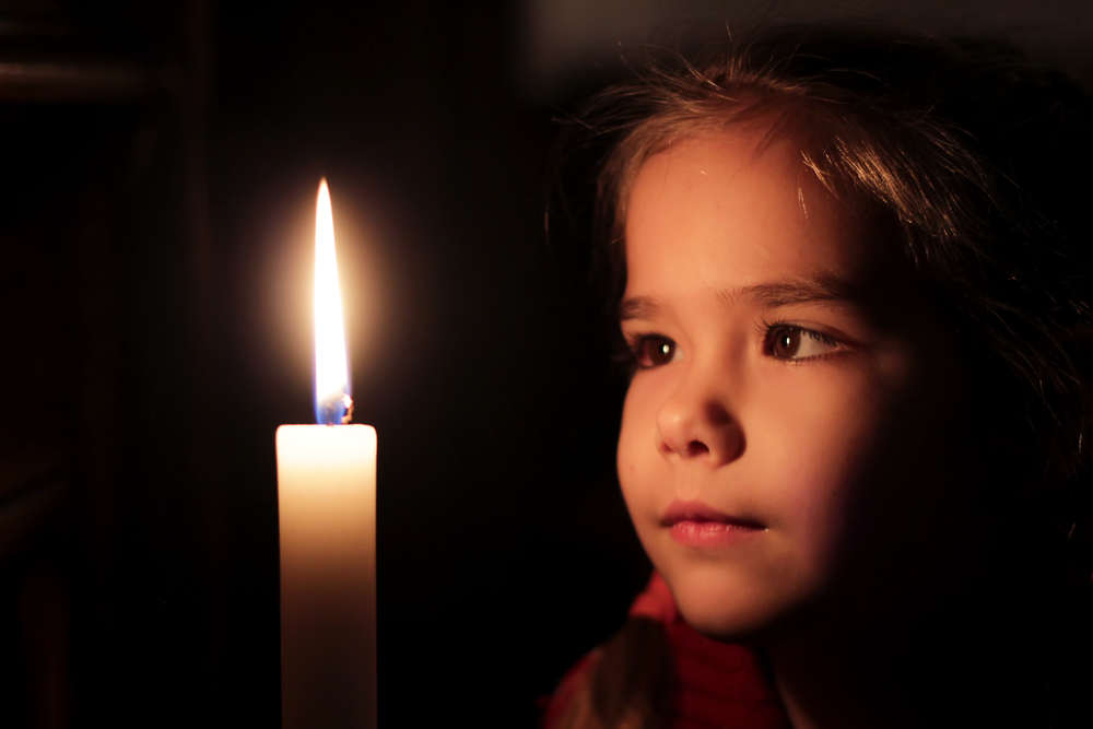 Pretty,Small,Girl,Is,Looking,On,The,Light,Of,Candle