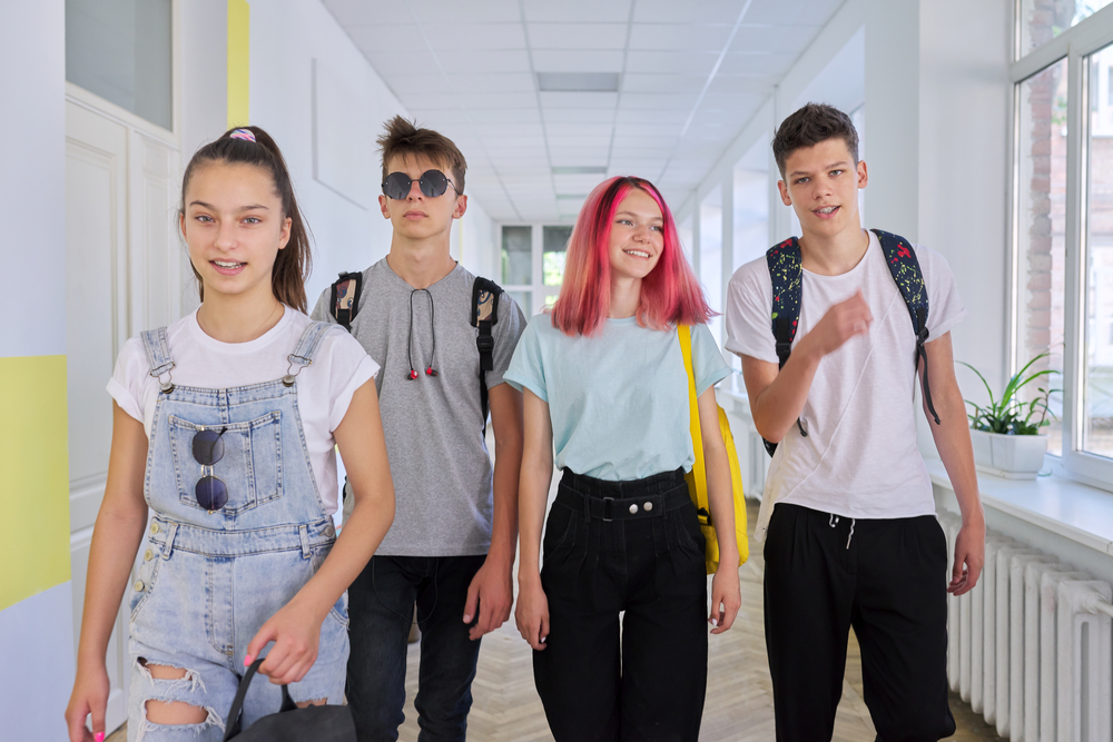 Group,Of,Teenage,Students,Walking,Together,Along,School,Corridor,,Schoolchildren