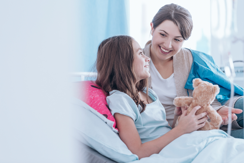 Sisters,Smiling,And,Lying,In,Bed,In,The,Hospital,Together.