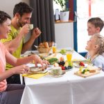 Sie sehen eine Familie beim Rauszeit-Frühstück im JUFA Hotel Maria Lankowitz. Der Ort für erholsamen Familienurlaub und einen unvergesslichen Winter- und Wanderurlaub.