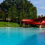 Freibad mit roter Rutsche in Neutal. JUFA Hotels bietet Ihnen den Ort für erlebnisreichen Natururlaub für die ganze Familie.