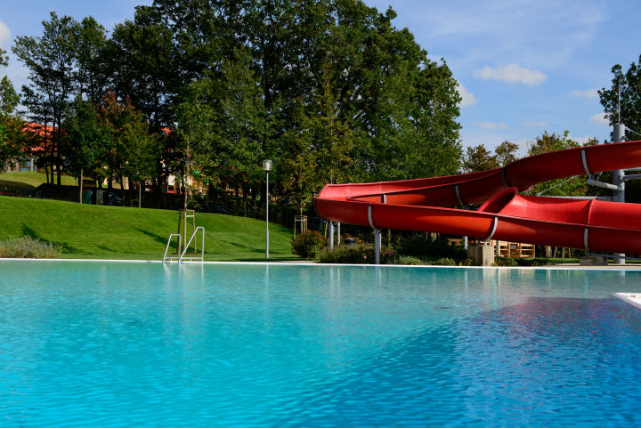 Freibad mit roter Rutsche in Neutal. JUFA Hotels bietet Ihnen den Ort für erlebnisreichen Natururlaub für die ganze Familie.