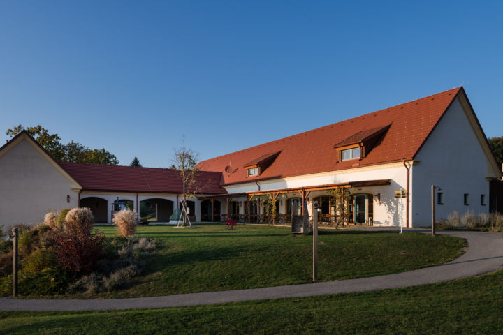 Sie sehen eine Außenansicht vom JUFA Hotel Neutal – Landerlebnis mit Garten im Herbst. JUFA Hotels bietet Ihnen den Ort für erlebnisreichen Natururlaub für die ganze Familie.