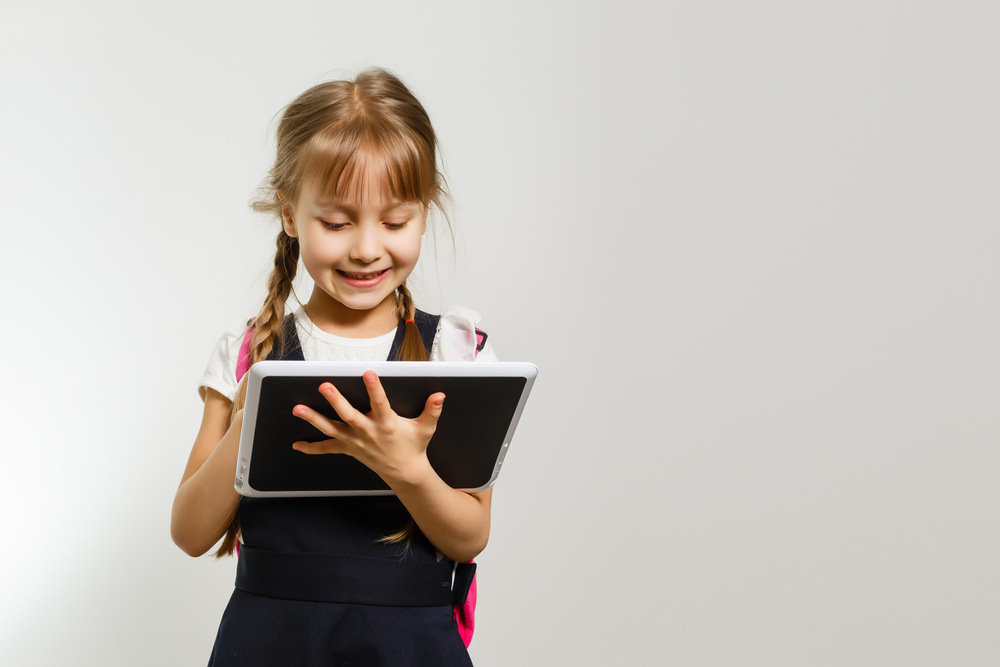 The,Little,Girl,Using,The,Tablet,On,The,White,Wall