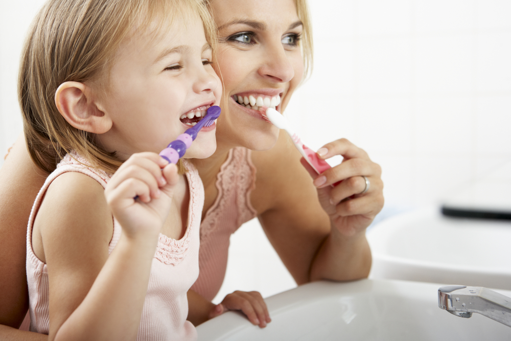 Mother,And,Daughter,Brushing,Teeth,Together