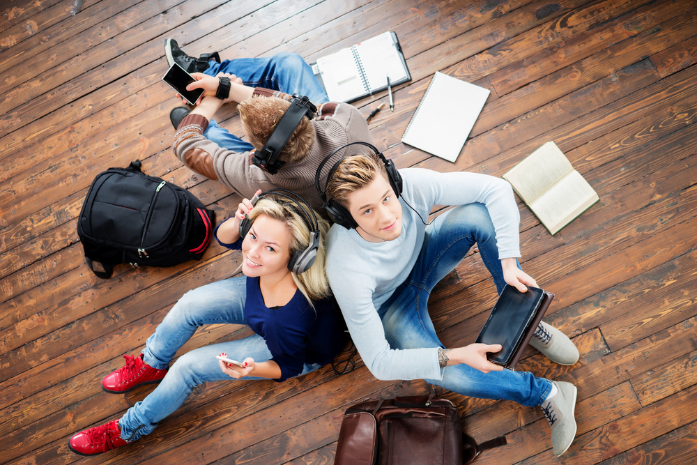 Group,Of,Students,Using,Smartphones,And,Tablet,In,Headphones,Listening