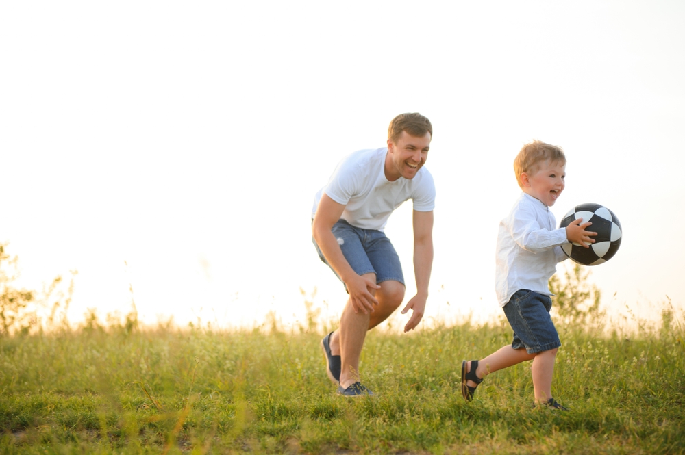 Father,With,A,Little,Son,Plays,Football,On,The,Green