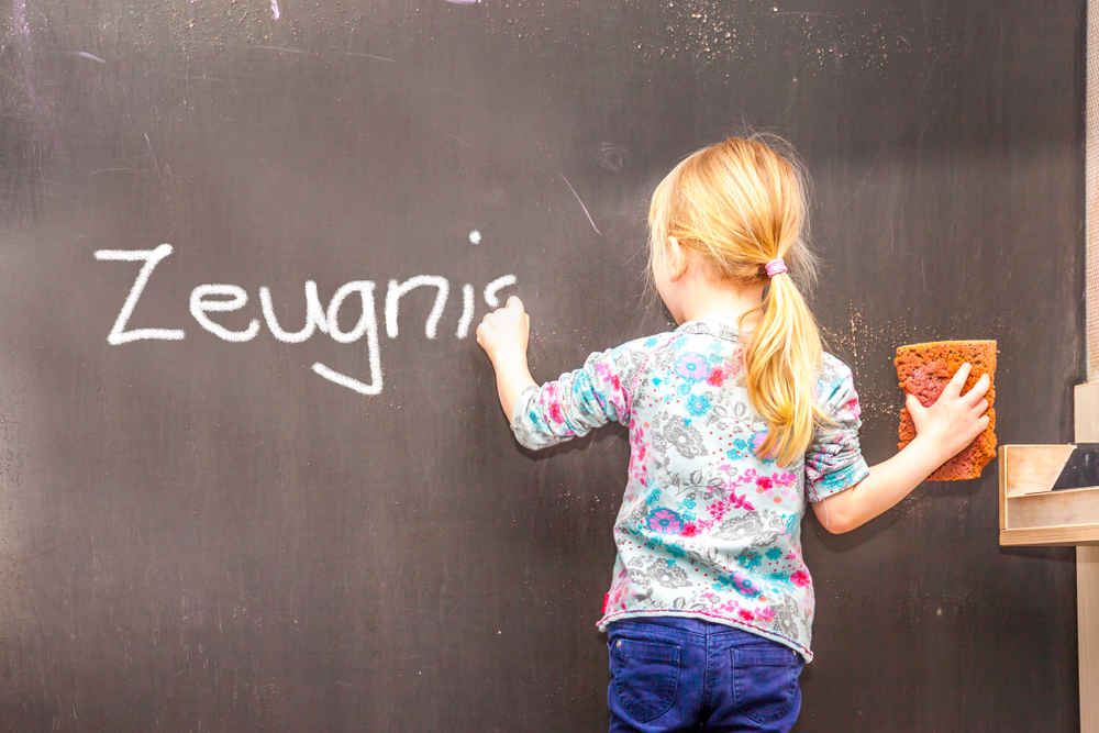 Cute,Little,Girl,Writing,Zeugnis,On,Chalkboard,In,A,Classroom