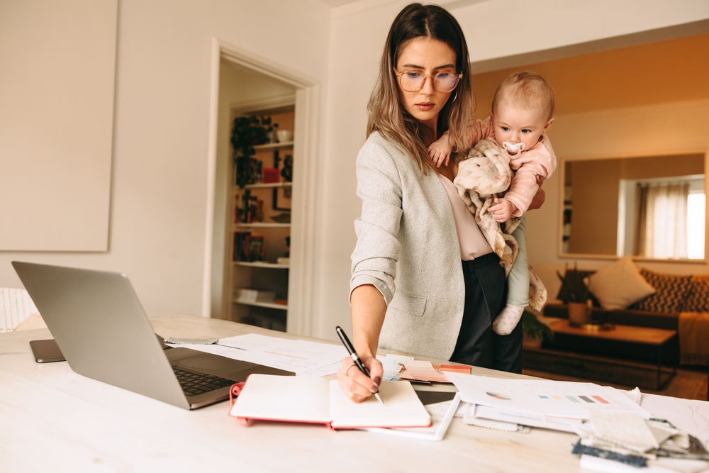 Female,Interior,Designer,Making,Notes,While,Holding,Her,Baby.,Multitasking