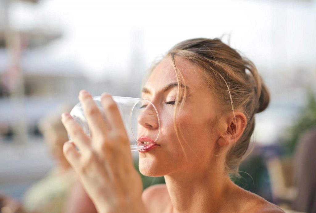 Frau trinkt aus Wasserglas Adrienn Pexels