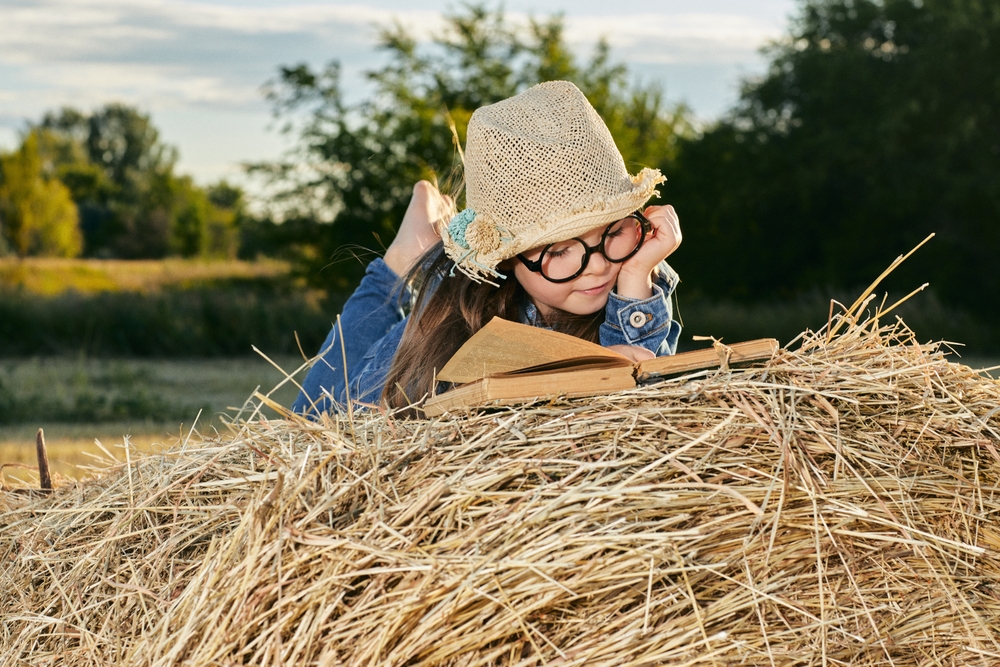 Reading,Girl,Sits,Over,The,Haystack,Roll,On,Field,In