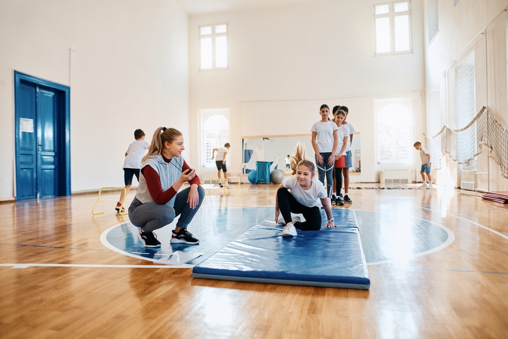 Young,Female,Coach,And,Group,Of,Kids,During,Exercise,Class